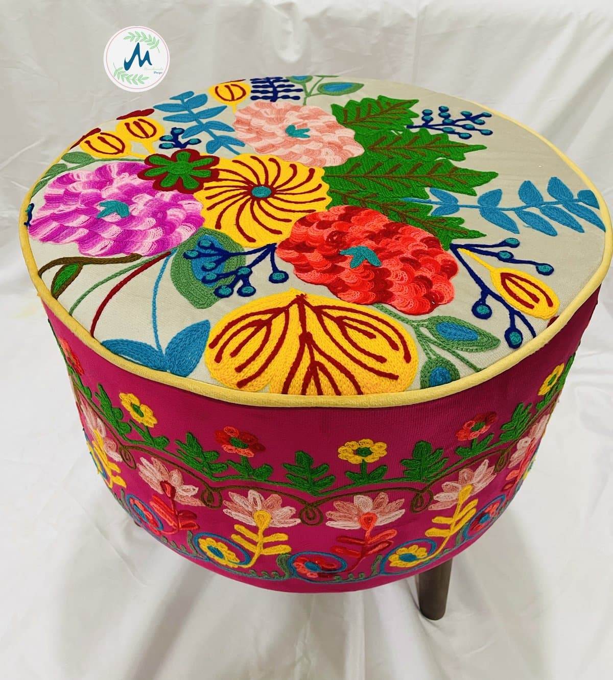 Maroon floral embroidered pouf with wooden legs