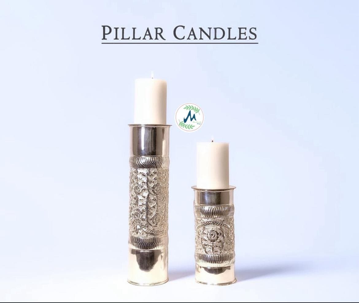 Engraved silver pillar candle holders with lit candles and marigolds